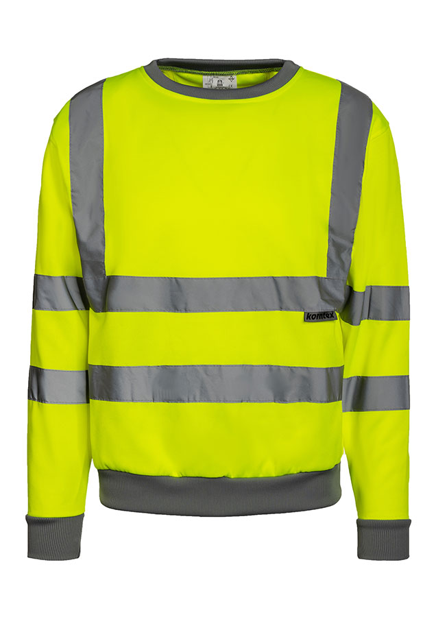 Erwachsener Mann steht in signal-gelbem Korntex Warnschutz-Sweatshirt und weißem Schutzhelm auf einer Baustelle