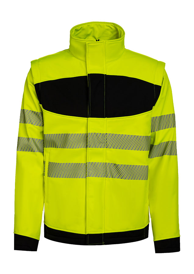 Erwachsener in signalgelber Korntex-Softshell Jacke mit schwarzer Brustpartie und Reflexstreifen in einem industriellen Umfeld