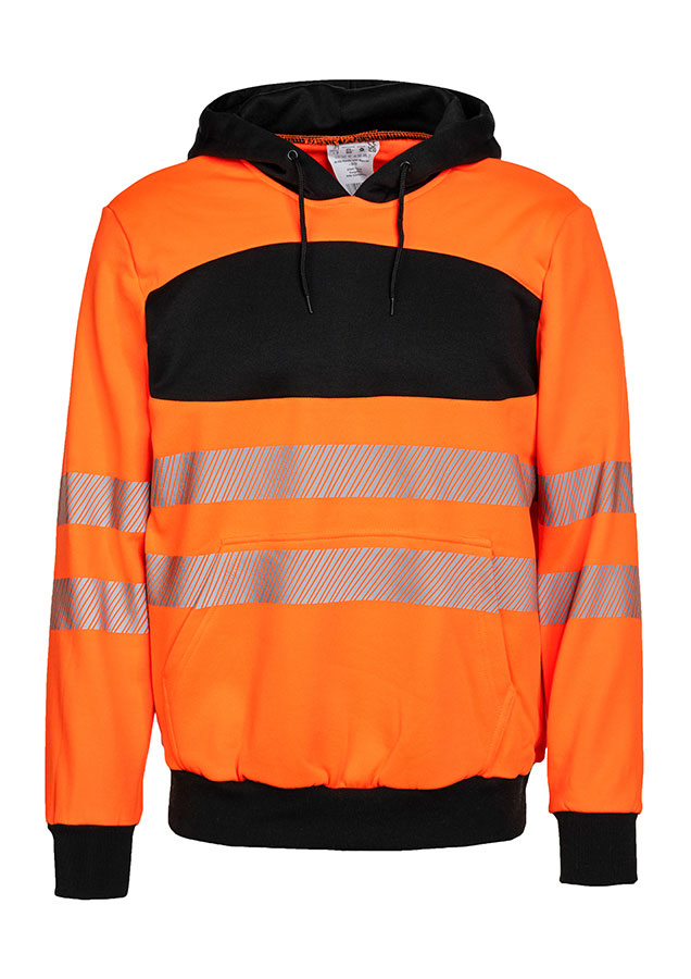 Erwachsener trägt einen orangefarbenen Korntex-Hoodie mit schwarzer Brustpartie in einem industriellen Umfeld