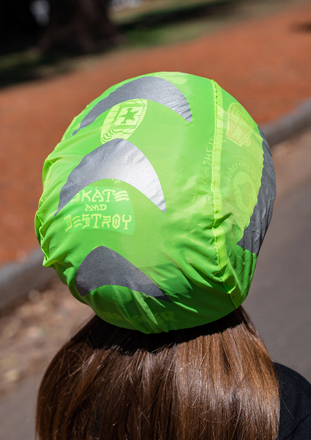 Detailansicht eines grünen Korntex Fahrradhelmüberzugs mit grafischem Designs auf dem Kopf einer jungen Frau