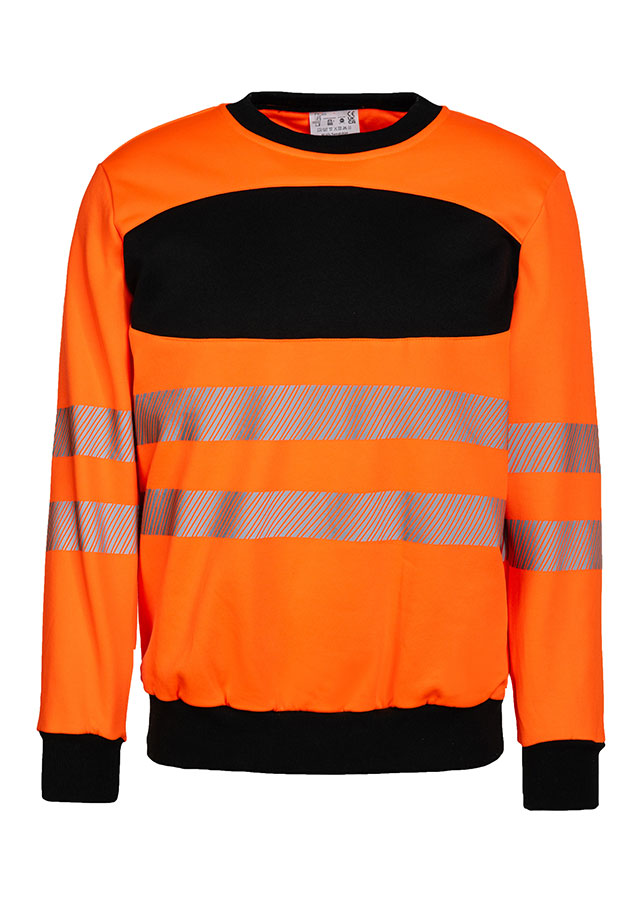 Erwachsener trägt ein gelbes Korntex-Sweatshirt mit schwarzer Brustpartie in einem industriellen Umfeld