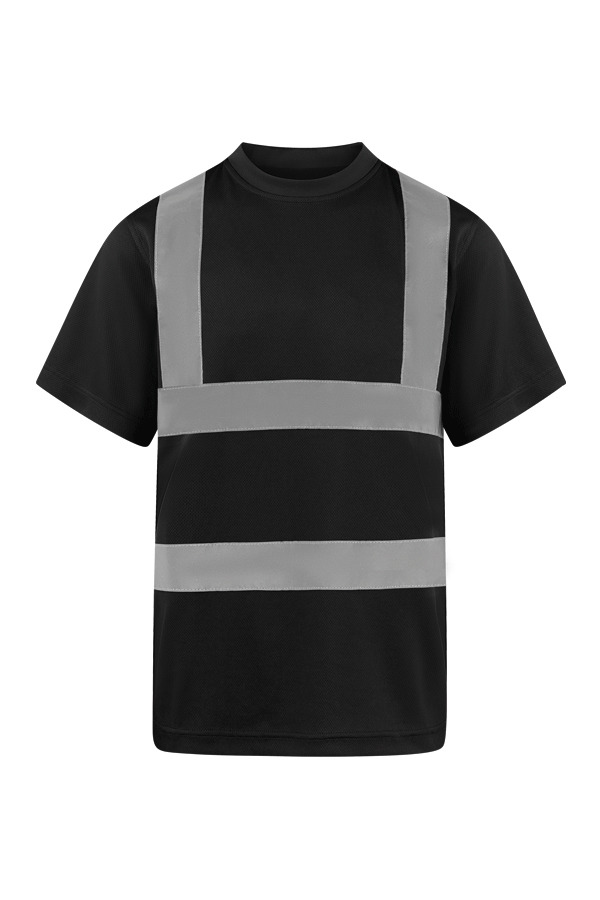 Erwachsene Frau steht in signal-orangenem Korntex Warnschutz-T-Shirt und weißem Schutzhelm vor einem Gerüst auf einer Industriebaustelle