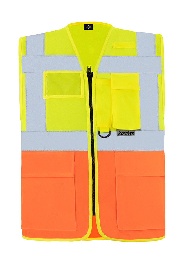 Bauarbeiter in orangener Korntex Multifunktionaler Warnweste und Schutzhelm kommuniziert über Funkgerät auf einer Baustelle