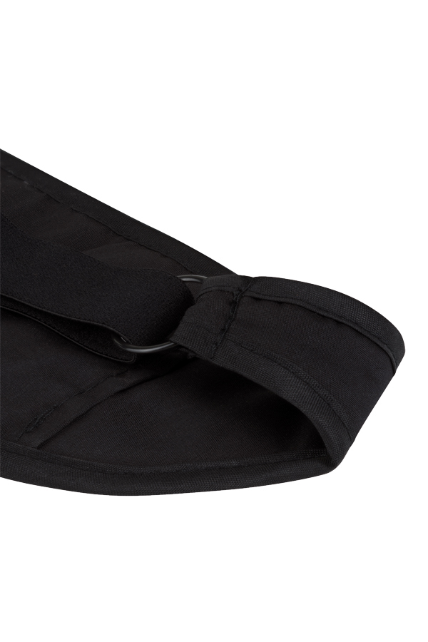Frau trägt eine schwarze Korntex-Schlafmaske, während sie auf einer Couch sitzt
