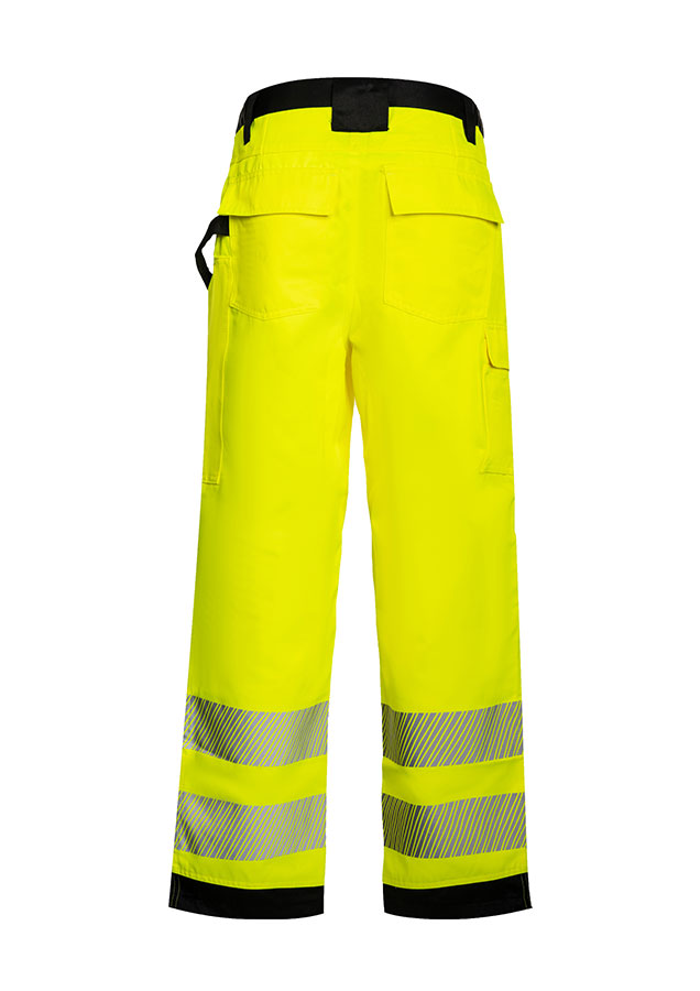 Erwachsener trägt unter anderem eine signalgelbe Korntex-Hose mit schwarzen Partien in einem industriellen Umfeld