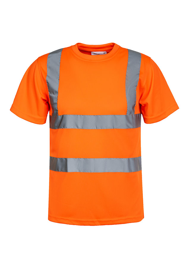 Erwachsene Frau steht in signal-orangenem Korntex Warnschutz-T-Shirt und weißem Schutzhelm vor einem Gerüst auf einer Industriebaustelle