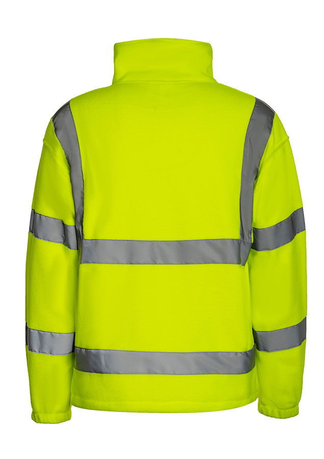 Erwachsener Mann läuft in signal-oranger Korntex Warnschutz-Fleecejacke mit Reflexstreifen vor einem Industriegebäude entlang.