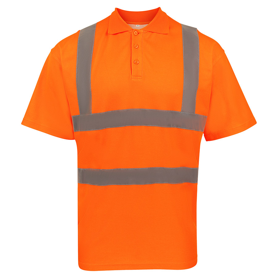 Männlicher junger Arbeiter in einem orangen Korntex Polo-Shirt mit Reflexstreifen hält eine Schaufel in einer baufälligen Umgebung