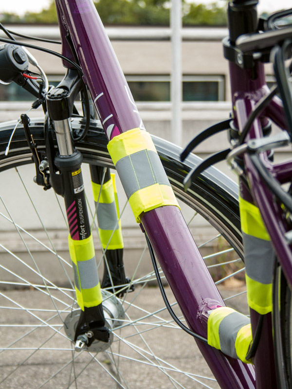 Detailansicht eines lilanen Fahrrads mit angebrachten gelben Korntex Sicherheitsreflektoren am Fahrrad-Rahmen
