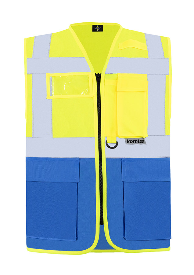 Bauarbeiter in orangener Korntex Multifunktionaler Warnweste und Schutzhelm kommuniziert über Funkgerät auf einer Baustelle