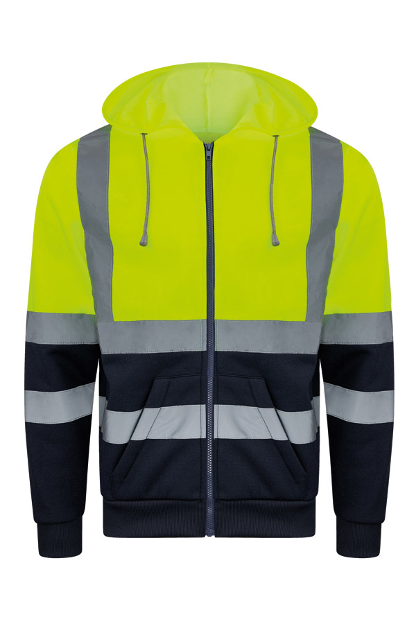 Erwachsener in signalgelbem Korntex-Hoodie mit Zipper und Reflexstreifen in einem industriellen Umfeld
