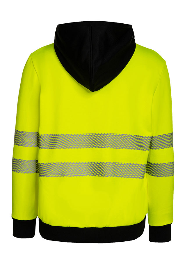 Erwachsener trägt einen orangefarbenen Korntex-Hoodie mit schwarzer Brustpartie in einem industriellen Umfeld
